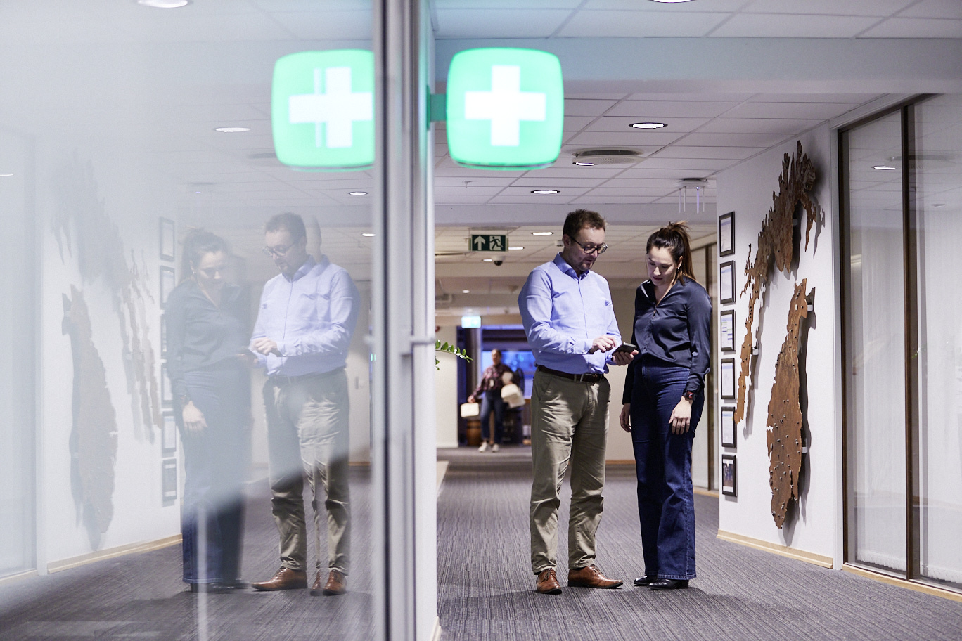 Two pharmacy workers standing in a hall in a hospital